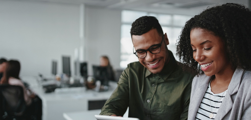 Business-agility_agile_orgs_photo_courses_young_professionals Two colleagues smile and confer at a desk